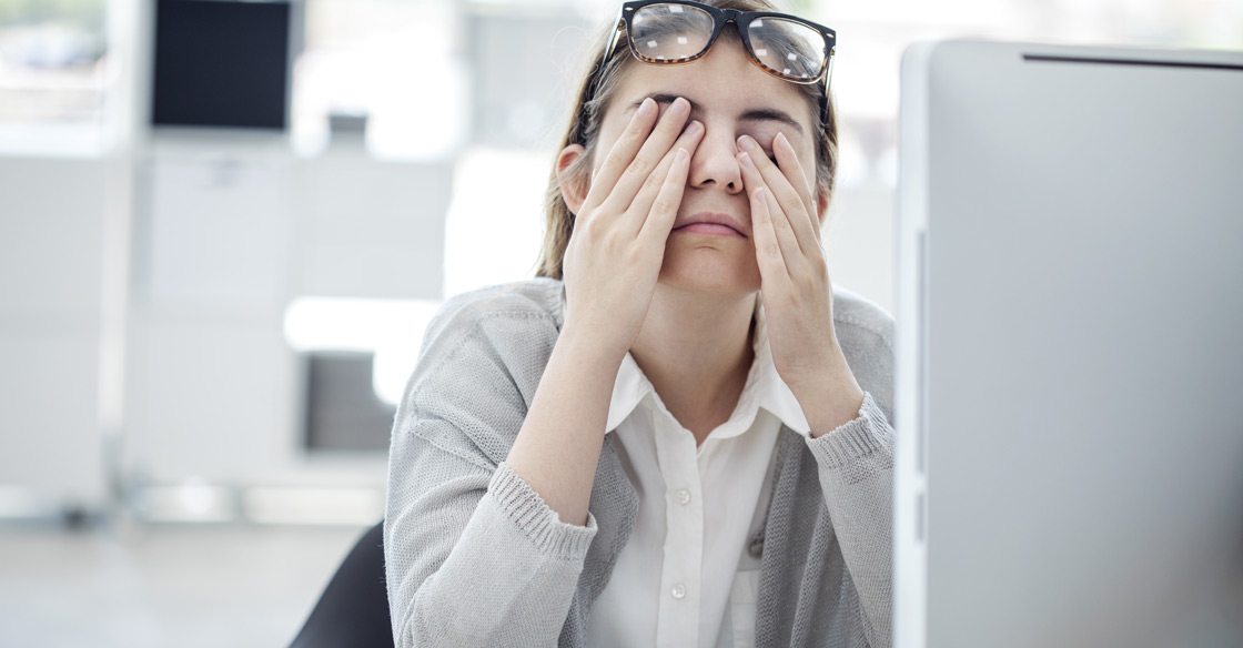 A woman at her computer rubbing her eyes