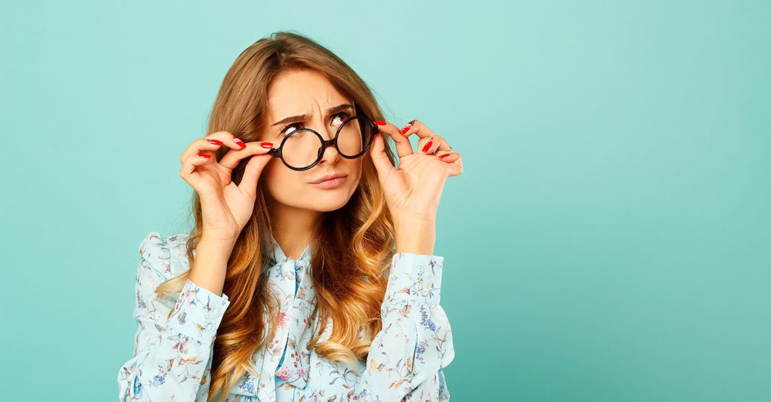 Do I need glasses - Woman looking over the frame of her glasses