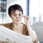 Woman with presbyopia reading a newspaper