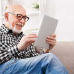 Man wearing progressive eye glasses looking at a tablet