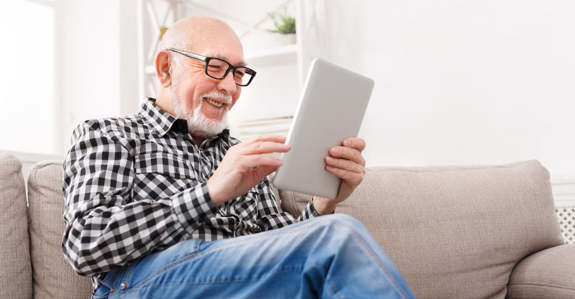 Man wearing progressive eye glasses looking at a tablet