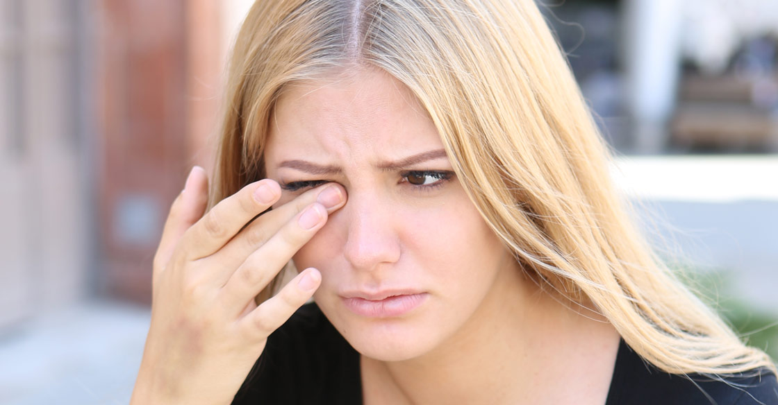 woman rubbing her watery eye