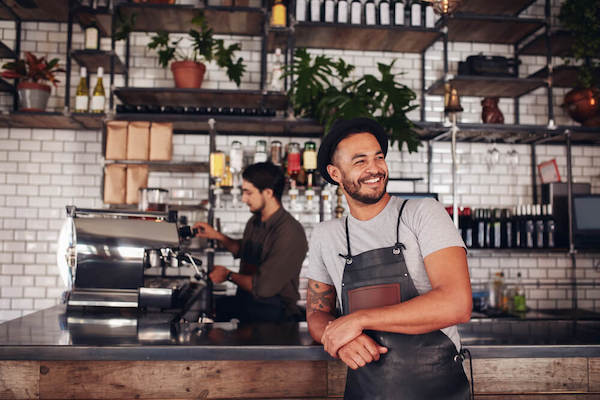 Cafe owner wearing a hat and apron but no glasses